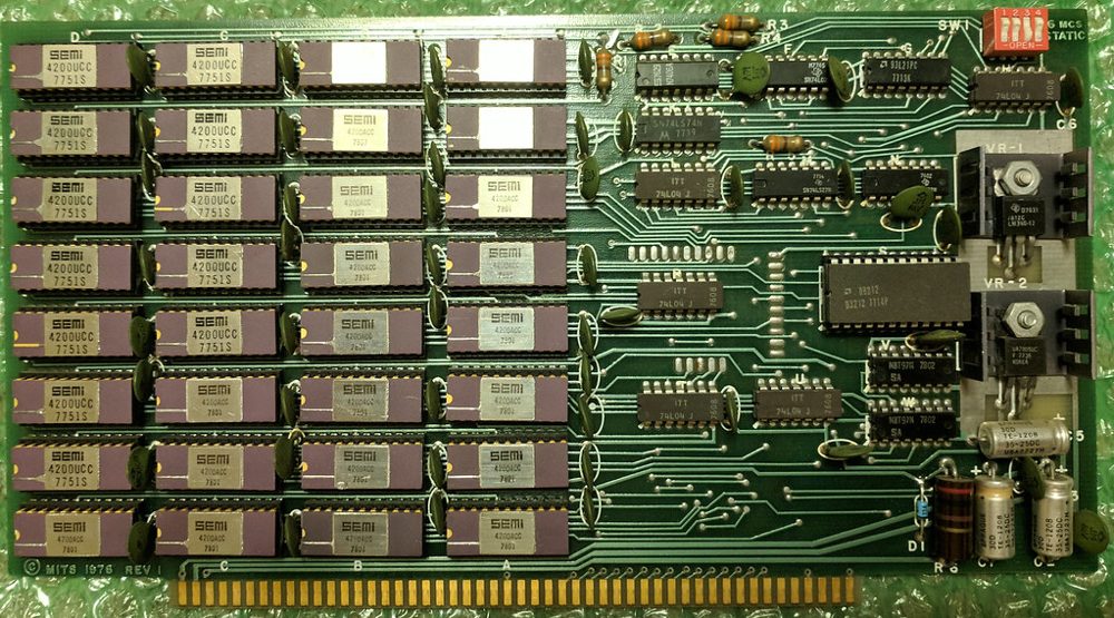MITS 88-16MCS 16K static memory board, component side: thirty-two ceramic 4200UCC RAM chips in eight rows on the left, TTL support logic and two voltage regulators on the right, MITS 1976 REV 1 silkscreen.